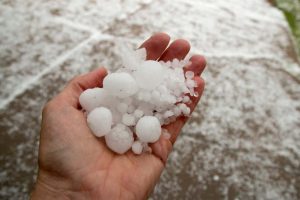 Hail in hand of storm restoration experts Dolan Roofing.