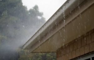 a roof and gutters in heavy rain