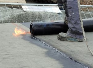 a roofer installs modified bitumen roofing