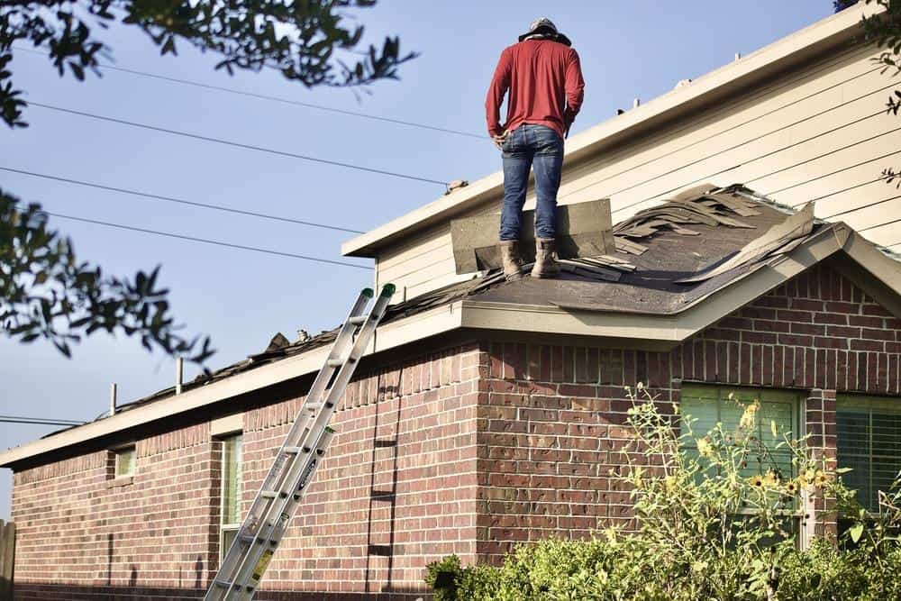 a roofer surveys a roof