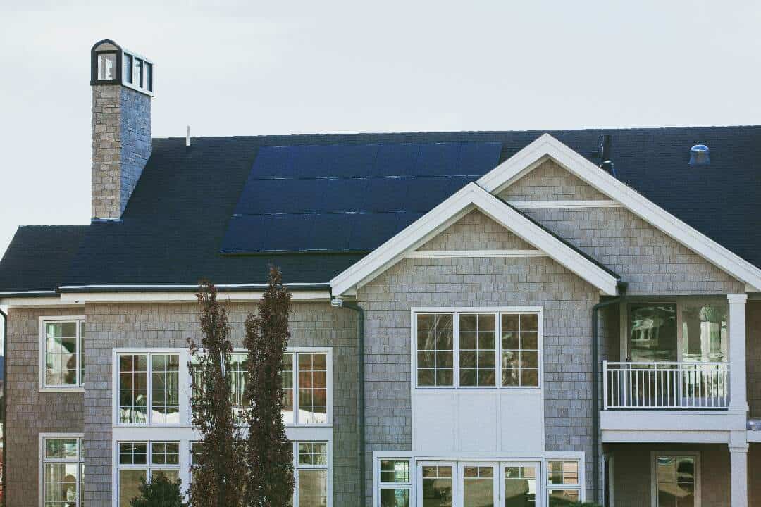an array of solar panels on the roof of a two story home