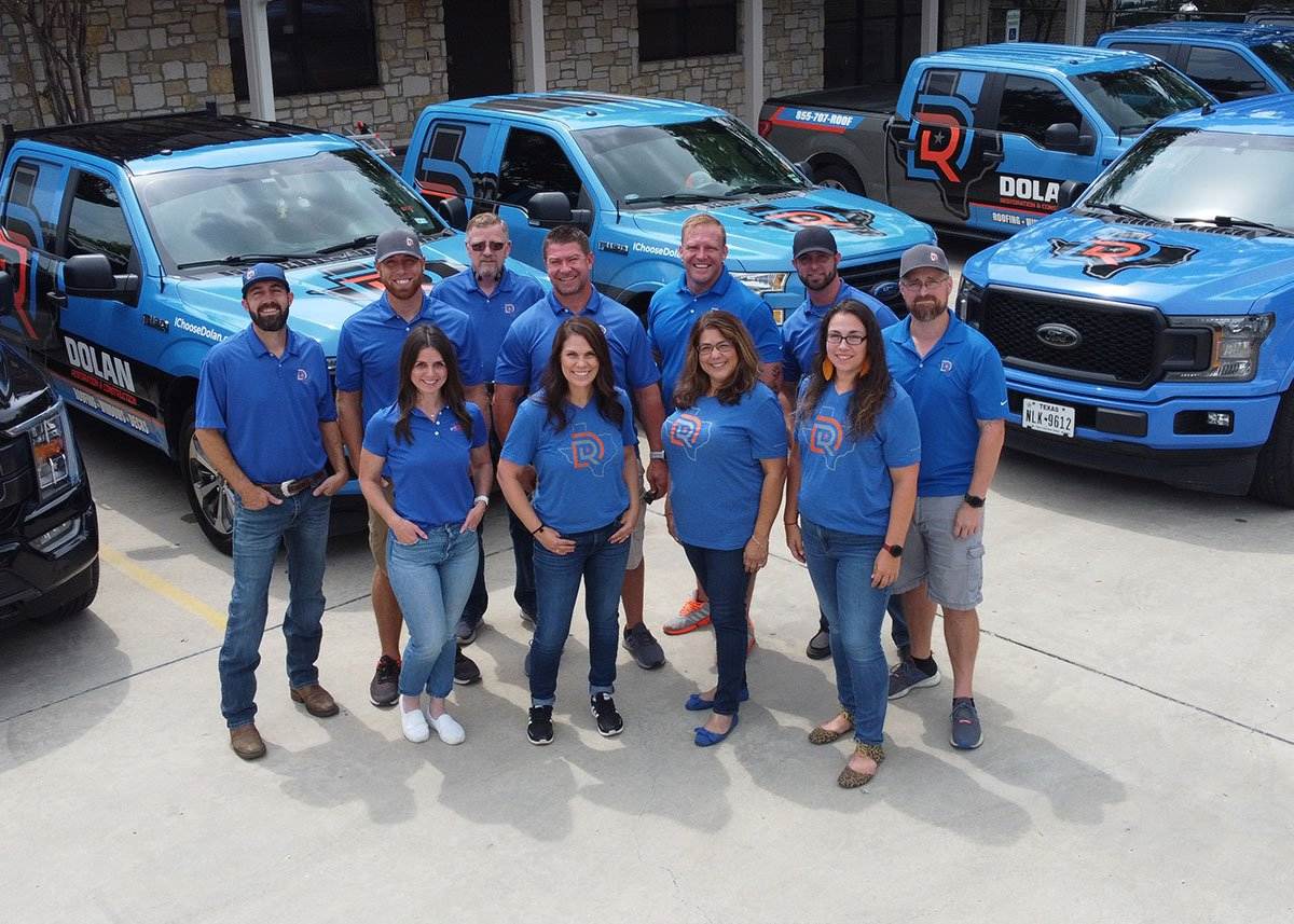 Dolan team photo in front of company trucks